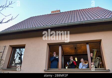 22 mars 2020, Brandenburg, Francfort (Oder): Famille Loichen, mère Dorothea, musicien à l'Orchestre d'Etat de Francfort (Oder), père Sven, professeur d'école de musique, et leurs enfants Emilia (2ème de gauche) et Alma sont debout à la fenêtre de leur maison et jouant 'Ode à Joy'. L'action à l'échelle de l'Allemagne est destinée à être un "règne de solidarité et de joie de vivre" pendant la crise de Corona. Photo : Patrick Pleul/dpa-Zentralbild/dpa Banque D'Images