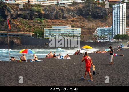 Touristes aux falaises de los gigantes plage de sable noir volcanique à Puerto de la Cruz, île de Tenerife, îles Canaries, Espagne Banque D'Images