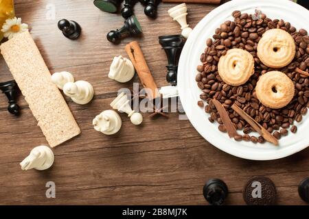 Plateau de cookies et figurines d'échecs sur une table en bois. Vue de dessus Banque D'Images