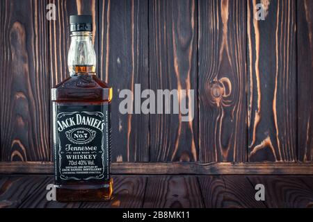 Kharkiv, Ukraine, 22 mars 2020: Une bouteille de verre pleine de whisky américain Jack Daniel sur fond de bois brun foncé. Boisson forte originale. Vide sp Banque D'Images
