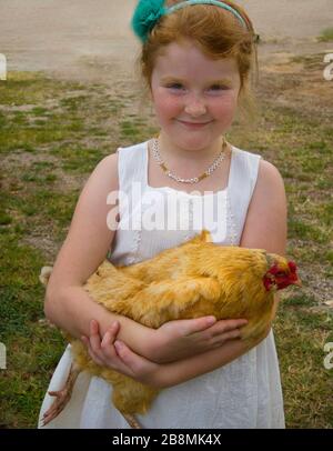 Jeune fille redoutée tenant la poule Banque D'Images