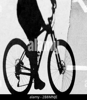Silhouette floue d'ombre d'une jeune femme à vélo, détails en noir et blanc Banque D'Images