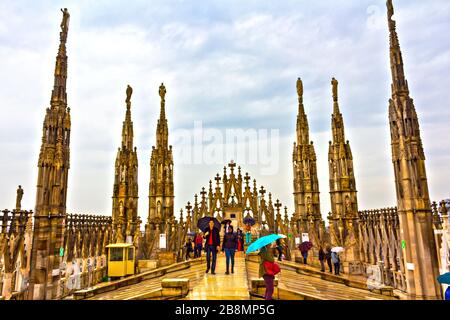 Les touristes peuvent visiter et profiter de la vue entourée par les flèches et les statues sur le toit de la cathédrale de Milan le printemps pluvieux, Italie, mai 2017 Banque D'Images