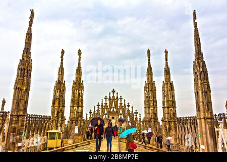 Les touristes peuvent visiter et profiter de la vue entourée par les flèches et les statues sur le toit de la cathédrale de Milan le printemps pluvieux, Italie, mai 2017 Banque D'Images