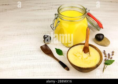 Ghee ou beurre clarifié dans le pot. Manger sain et utiliser des produits bio frais. Ingrédient sain pour la cuisine de repas bio.Spoon avec ghee mais Banque D'Images