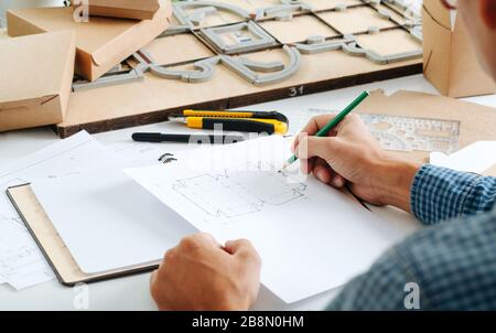 Designer homme assis au bureau travaillant sur la création d'un nouveau ECO box Banque D'Images