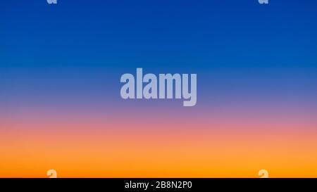 Une multitude de couleurs au lever du soleil, du jaune vif et de l'orange près de l'horizon au bleu profond plus haut dans l'atmosphère Banque D'Images