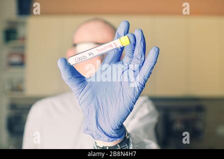 Le médecin détient le vaccin COVID 19 Coronavirus dans sa main, échantillon infecté dans le tube échantillon, vaccin et injection de seringue qu'il utilise pour la prévention Banque D'Images
