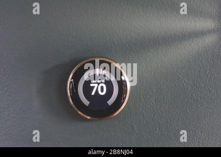 Thermostat domestique intelligent isolé au mur avec rayons de soleil en streaming à partir de l'appareil photo. Économiser de l'énergie avec la maison de nid Banque D'Images