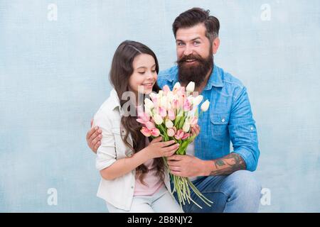 Fête d'anniversaire. Journée internationale de la femme. Fleuriste. Tradition familiale. Elle vaut tous les trésors. Tulipes tendre pour fille. Bouquet de tulipes d'homme. Père donnant des tulipes fille. Père avec fleurs. Banque D'Images