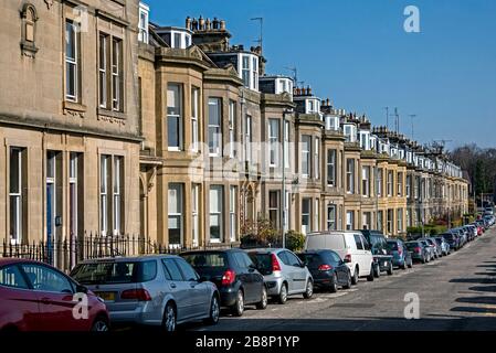 Rangée de voitures garées à l'extérieur de maisons mitoyennes dans la région d'Inverleith, à Édimbourg, en Écosse, au Royaume-Uni. Banque D'Images