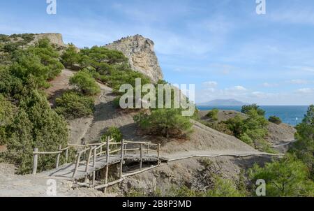 Vue panoramique avec petit pont en bois sur le sentier de Golitsyn dans le relict grove à la réserve naturelle de Karal-Oba avec le pic de la montagne de Koba-Kaya près de Novy Svet (N Banque D'Images