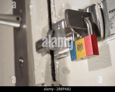 Une porte boulonnée fixée par un cadenas avec le drapeau national de la Moldavie dessus.(série) Banque D'Images