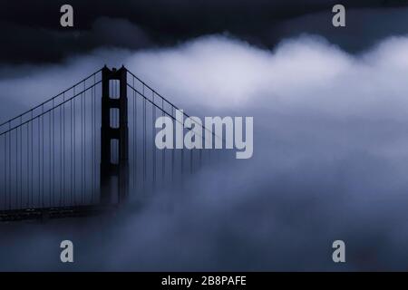 Golden Gate Bridge partiellement obscurci par le brouillard au crépuscule, San Francisco, Californie, États-Unis, Amérique du Nord, monochrome bleu Banque D'Images