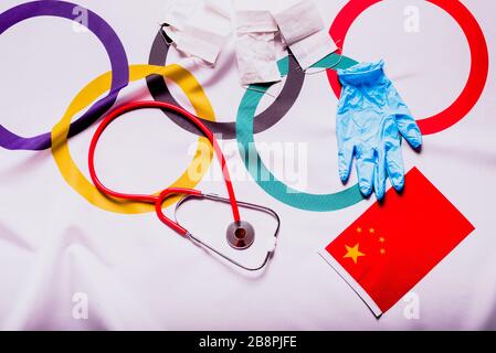 Valence, Espagne - 20 mars 2020: Drapeau olympique caché avec des fournitures médicales pendant l'annulation des Jeux Olympiques de Tokyo. Banque D'Images