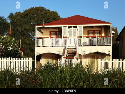 Vieille maison: Un vieux Queenslander tourné en couleur avec deux étages, des marches et une belle véranda devant. Banque D'Images