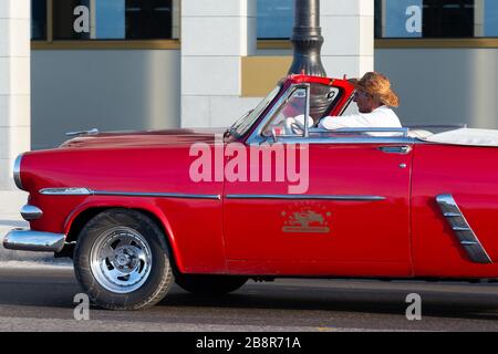 Voiture Ford classique de couleur rouge conduite par un cubain. Les voitures anciennes sont toutes autour de la Havane, Cuba, spécialement dans le centre-ville de la Habana chauffeur avec chapeau de paille Banque D'Images