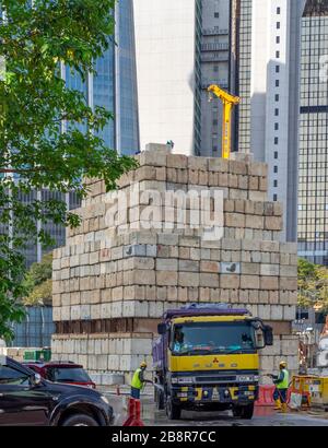 Des blocs de ciment de chantier sont mis en place comme contrepoids pour une grue et un camion a été déraclé par deux ouvriers Kuala Lumpur Malaisie. Banque D'Images