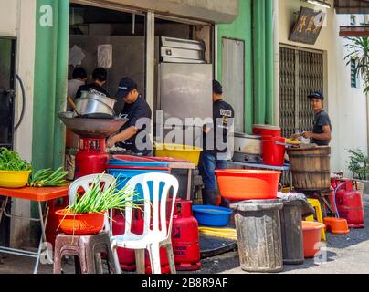 Les personnes préparant des repas à l'extérieur à l'arrière d'un restaurant sur la voie de Lorong Panggung Chinatown Kuala Lumpur Malaisie. Banque D'Images