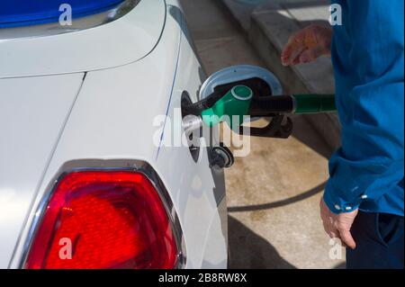 Un homme remplissant un réservoir de voiture avec du carburant, jour ensoleillé gros plan Banque D'Images