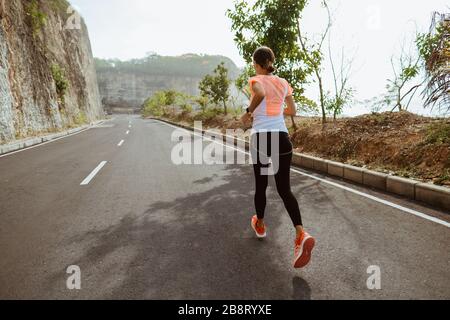 femme de sport courir sur sideroad. femme de sport courir sur la route vide Banque D'Images