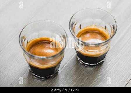 Café espresso double dose dans les verres sur fond de table en bois vintage Banque D'Images