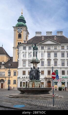 Vienne, Autriche. Fontaine d'Autriche (Austriabrunnen) sur la place Freyung en face du Schottenkirche. Banque D'Images