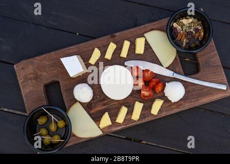 Plaque à fromage. Assortiment de différents fromages à base de noix et d'olives. Banque D'Images
