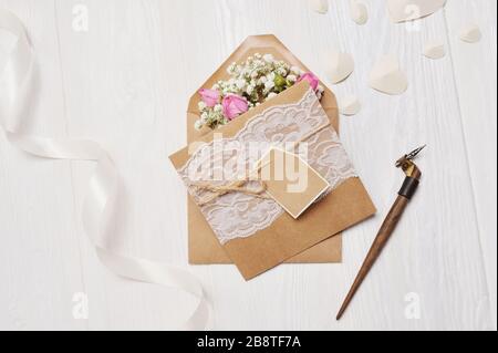 Plume calligraphique une enveloppe avec des fleurs et une lettre, carte de salutation pour la Saint Valentin avec place pour votre texte. Maquette de photo à écran plat et vue sur le dessus Banque D'Images