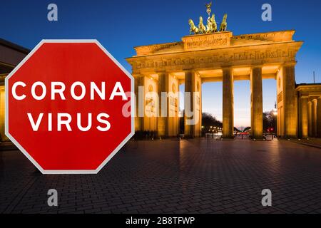 Berlin, Allemagne - 20 mars 2020: Image conceptuelle avec grand panneau rouge d'avertissement de Coronavirus devant la porte de Brandebourg au crépuscule, conc. De restriction de voyage Banque D'Images