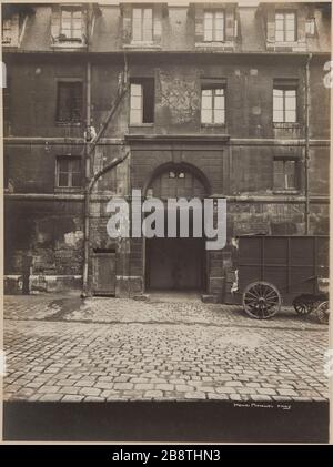 Vue sur l'entrée principale, prise dans la première cour vers la rue avec cadran solaire datant de 1683. Prison Saint-Lazare, prison pour femmes, 107 rue du Faubourg Saint-Denis, 10ème arrondissement, Paris. Vue de l'entrée principale, pry dans la première cour en direction de rue, avec cadran solaire daté de 1683. Prison Saint-Lazare, maison d'arrêt pour femmes, 107 rue du Faubourg-Saint-Denis. Paris (Xème arr.). Photographie d'Henri Manuel (1874-1947). Rage gélatino-argentique au bromure sur papier, collage sur une page d'album cartonnée. Agrandisation d’après une plaque négative sur verre. 1929-19 Banque D'Images