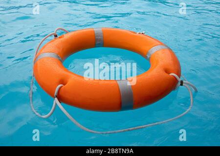 Bouée de sauvetage orange en mer sur l'eau. Anneau de vie flottant au-dessus de l'eau. Anneau de vie dans l'océan. Banque D'Images