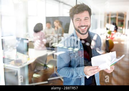 L'homme en tant que fondateur réussi du démarrage avec des papiers est heureux d'une commande Banque D'Images