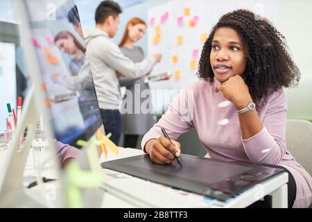 Femme africaine en tant que graphiste dans la formation sur tablette ordinateur Banque D'Images