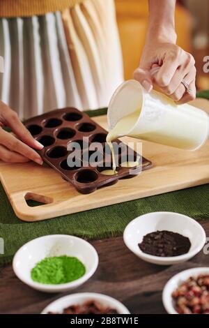 Image rapprochée de la femme qui verse du savon liquide dans un moule en plastique Banque D'Images