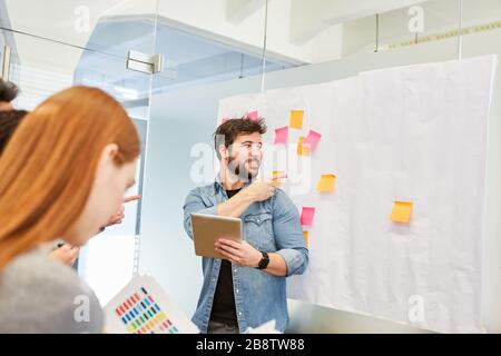 Conseiller l'homme ou l'entraîneur dans la réunion de brainstorming lors de l'évaluation des idées Banque D'Images