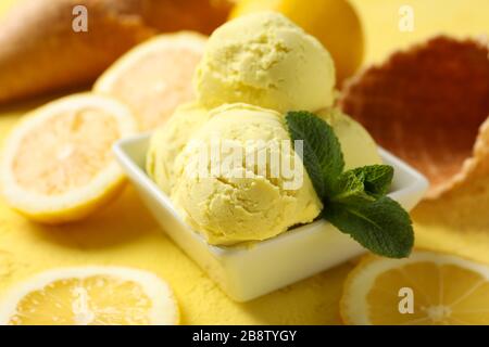 Glace, cuillère, citron et gaufres sur fond jaune, gros plan Banque D'Images