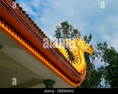 Statue de dragon d'or sur le toit du temple chinois. Symbole oriental traditionnel Banque D'Images