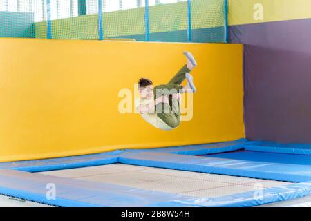 Un adolescent sautant sur le parc du trampoline dans le centre sportif Banque D'Images