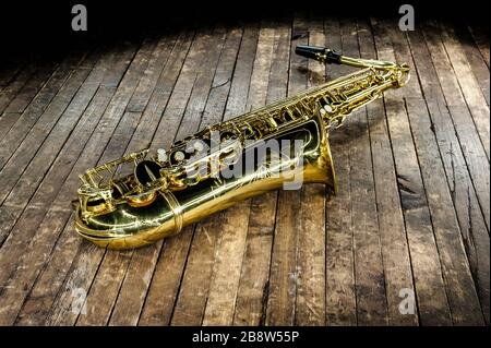 le magnifique saxophone doré se trouve sur un sol en bois Banque D'Images