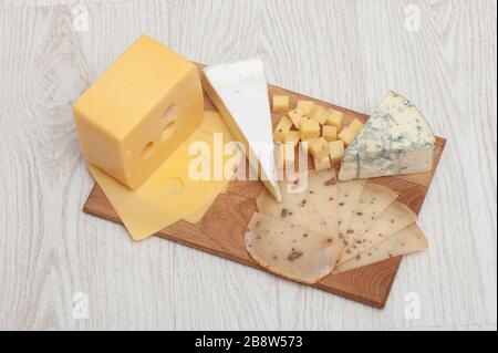 Différents types de fromage Roquefort, fromage à la noix, brie, sur une planche en bois. Banque D'Images