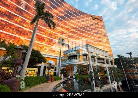 Le coucher du soleil se reflète dans la façade principale du Wynn Macau, un hôtel de luxe et un casino. Macao, Chine. Banque D'Images