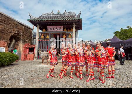 Filles en costumes traditionnels rouges se posant devant le temple Na Tcha. Macao, Chine. Banque D'Images