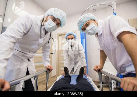 Les médecins dans un masque blanc de protection virale, regarde dans la caméra d'en haut comme vous en tant que patient. Ils travaillent sur la façon d'arrêter l'épidémie de la Banque D'Images