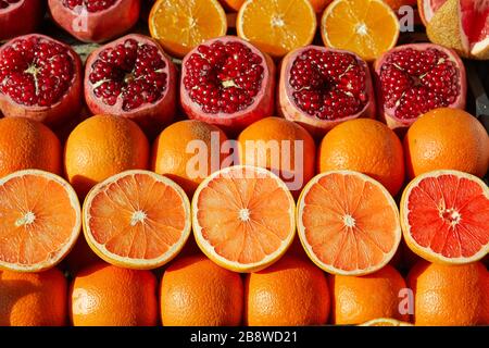 Oranges et grenades sur un comptoir d'un vendeur de jus. Les fruits sont disposés sur la fenêtre d'un vendeur de rue, entier et demi. Banque D'Images