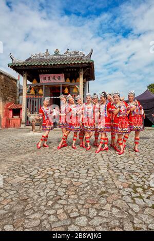 Filles en costumes traditionnels rouges se posant devant le temple Na Tcha. Macao, Chine. Banque D'Images