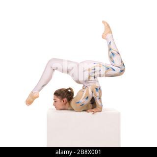 Acrobat faisant de la gymnastique, un jeune artiste de cirque dans un costume blanc et bleu, exécute des éléments acrobatiques. Studio photo isolé sur fond blanc Banque D'Images