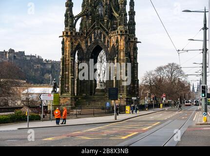 Edinburgh, Écosse, Royaume-Uni. 23 mars 2020. Des rues vides pendant la pandémie de Coronavirus de Covid-19 dans la capitale, comme le message de rester à la maison en compte les mesures de distanciation sociale semble avoir eu un effet malgré le beau soleil de printemps. Princes Street est déserté à part des bus qui desservent un service réduit et les vendeurs de bus sont inactifs en raison du manque de clients et de touristes Banque D'Images