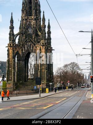 Edinburgh, Écosse, Royaume-Uni. 23 mars 2020. Des rues vides pendant la pandémie de Coronavirus de Covid-19 dans la capitale, comme le message de rester à la maison en compte les mesures de distanciation sociale semble avoir eu un effet malgré le beau soleil de printemps. Princes Street est déserté à part des bus qui desservent un service réduit et les vendeurs de bus sont inactifs en raison du manque de clients et de touristes Banque D'Images