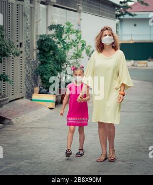 Femme et fille portant un masque facial jetable pour éviter l'infection virale. Protection contre le coronavirus Banque D'Images